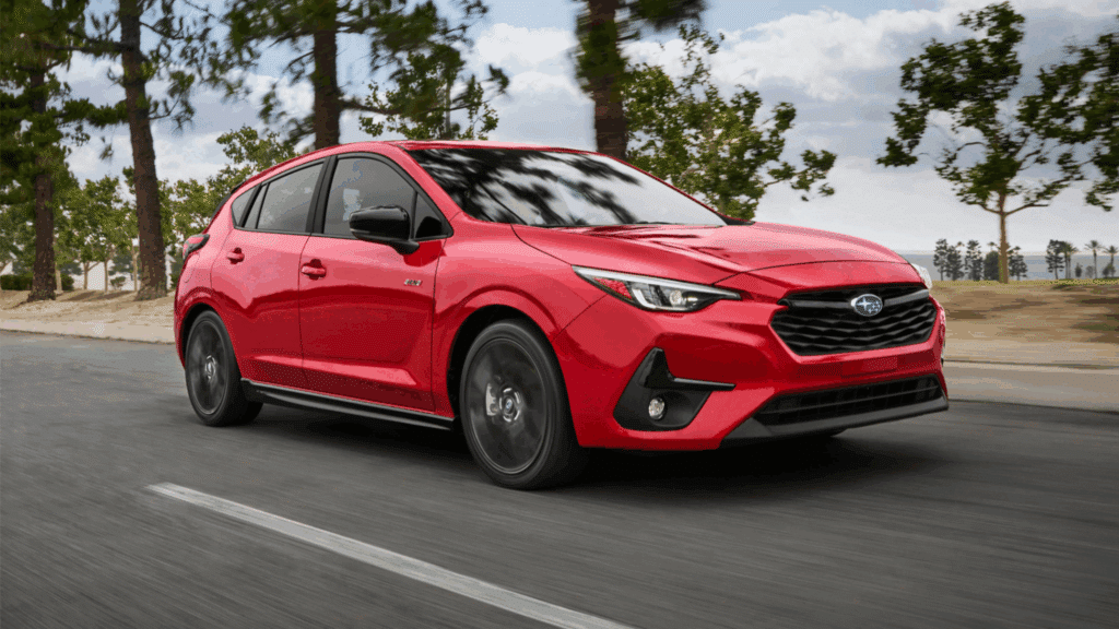 Red Subaru vehicle driving on a tree-lined road, showcasing Subaru's commitment to safety and performance, relevant to certified collision repair services at db Orlando Collision.