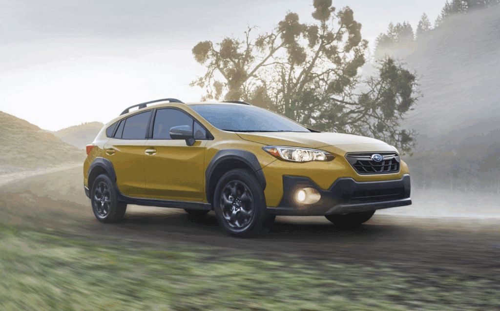 Subaru Crosstrek driving on a dirt road, showcasing its rugged design and advanced safety features, emphasizing Subaru-certified collision repair and safety standards.