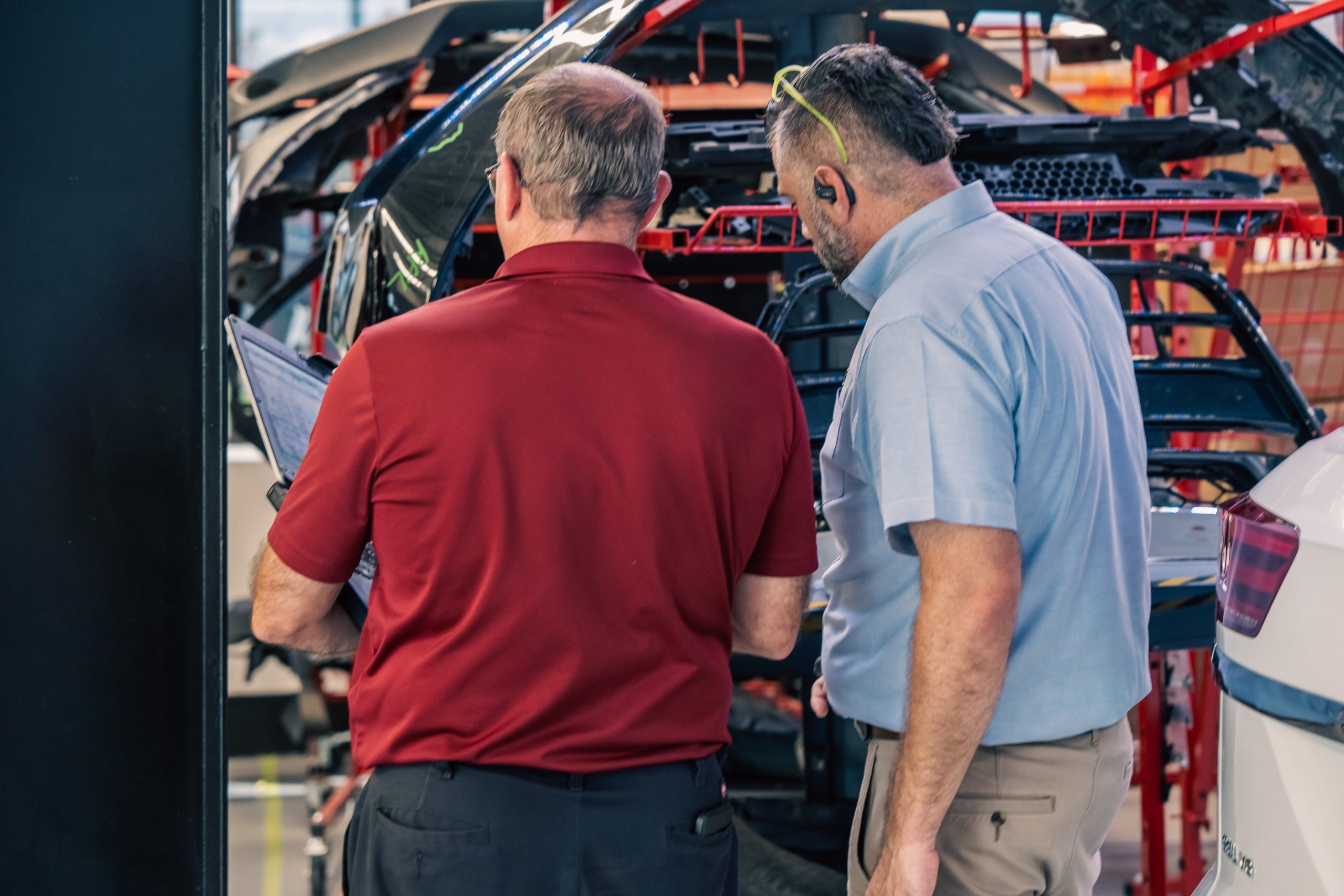 db Orlando Collision technicians reviewing OEM repair documentation during a collision repair in Orlando, FL