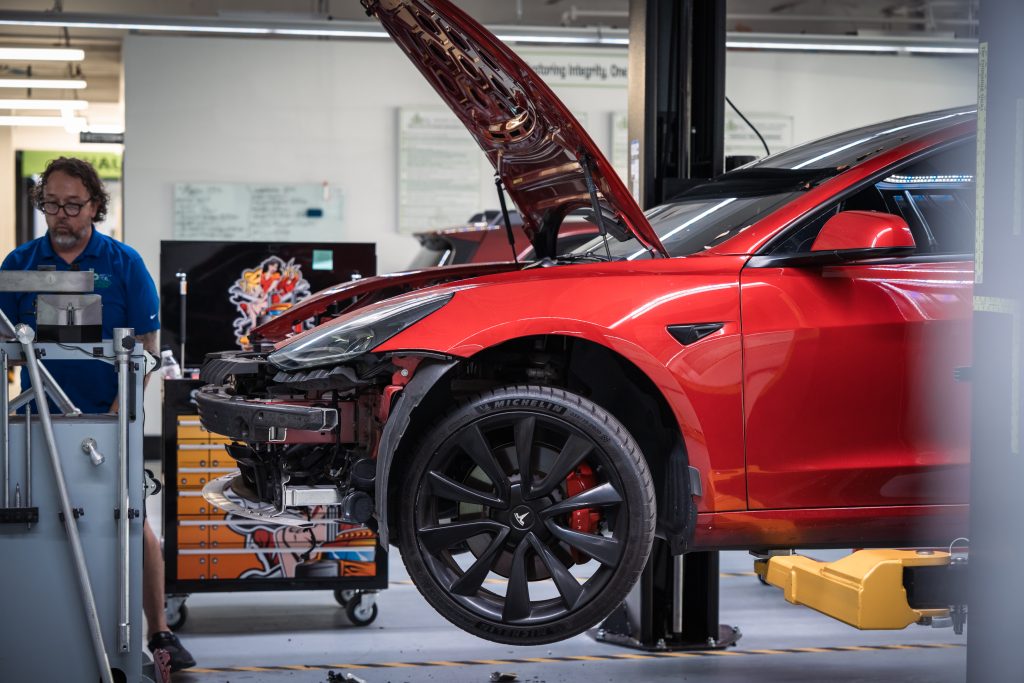 db Orlando Collision technician performing structural frame repair on a Tesla at Orlando OEM-certified auto body shop