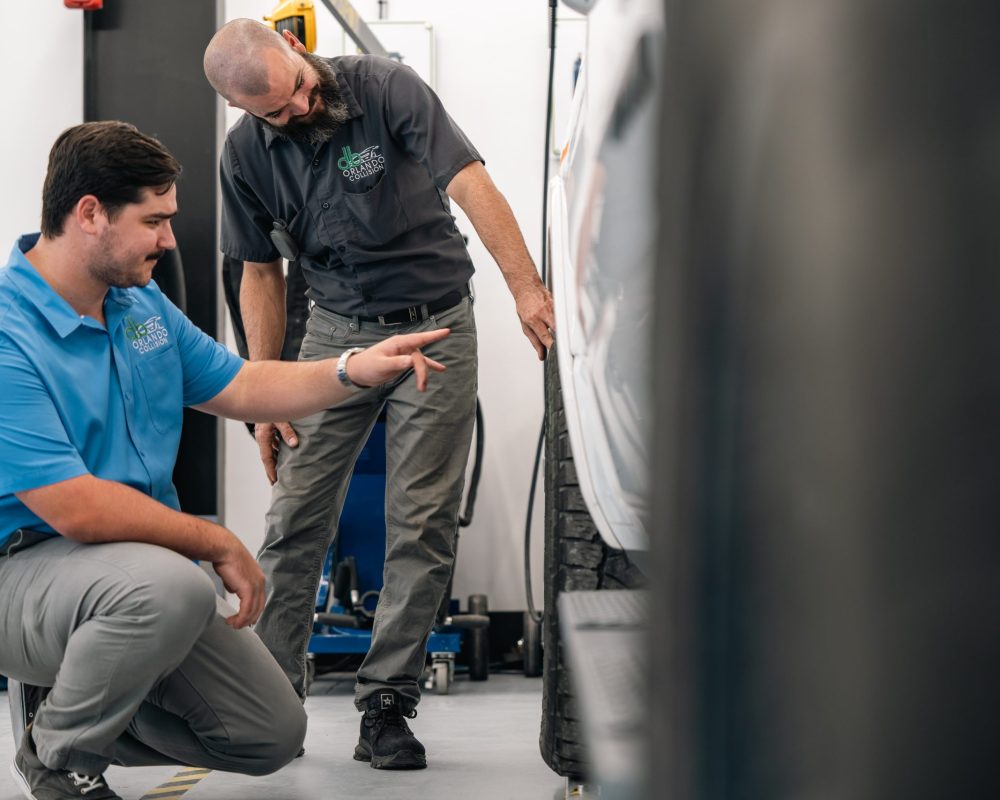 b Orlando Collision technicians inspecting vehicle alignment during OEM-certified collision repair in Orlando, FL